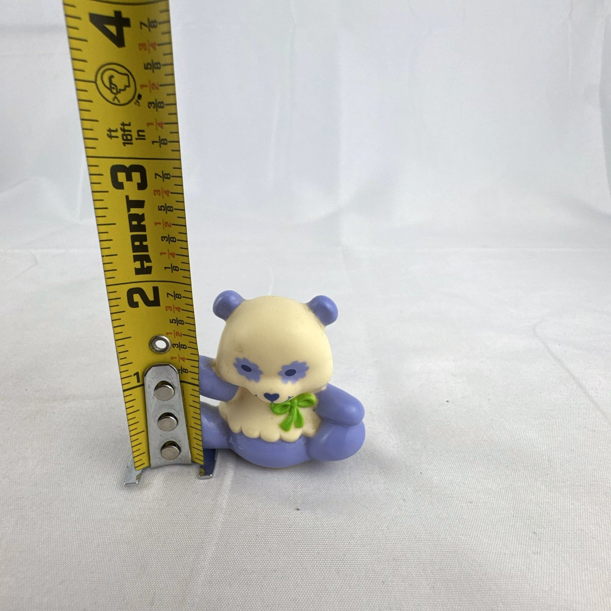 Vintage miniature purple and cream PVC vinyl panda bear figurine with green bow and flower-shaped eyes