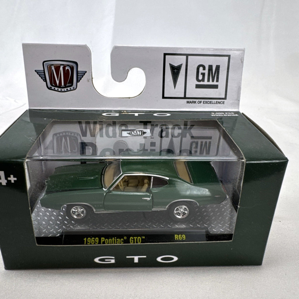 M2 Machines 1:64 scale 1969 Pontiac GTO diecast car in green, factory sealed in acrylic display case
