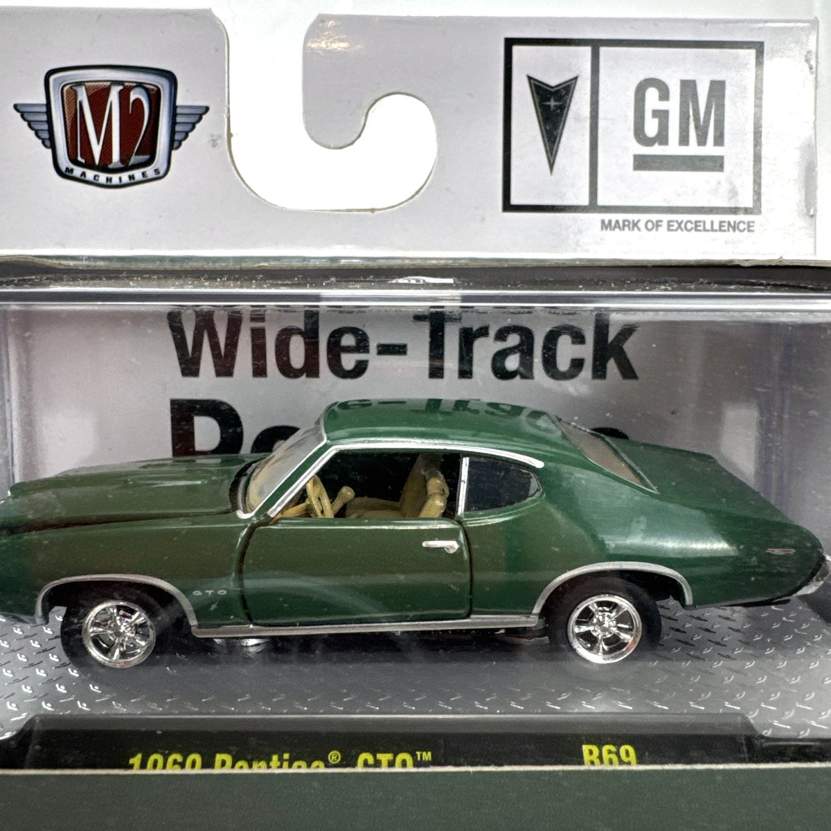 M2 Machines 1:64 scale 1969 Pontiac GTO diecast car in green, factory sealed in acrylic display case