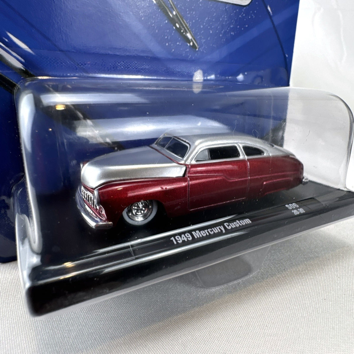 M2 Machines 1:64 scale 1949 Mercury Custom diecast car in metallic red and silver