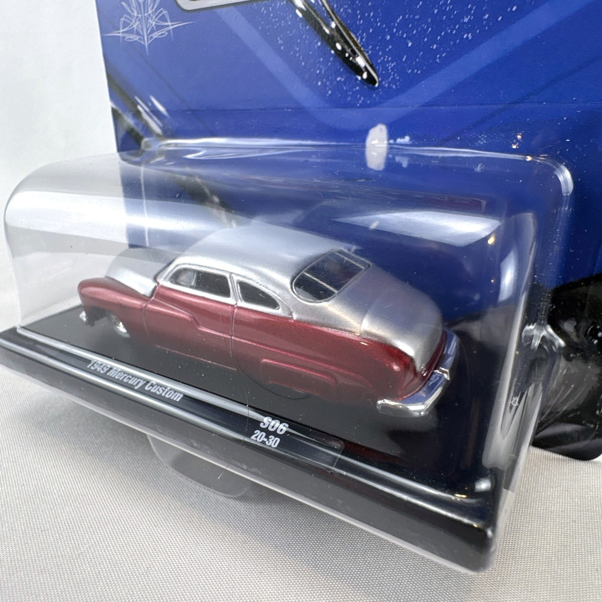 M2 Machines 1:64 scale 1949 Mercury Custom diecast car in metallic red and silver