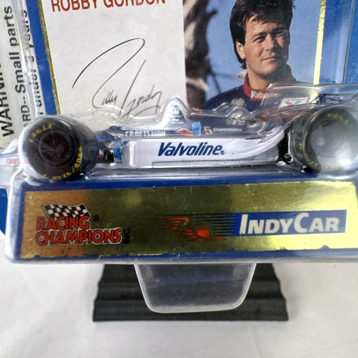 Racing Champions 1:64 diecast Robby Gordon #5 Valvoline IndyCar in factory-sealed blister pack with display stand