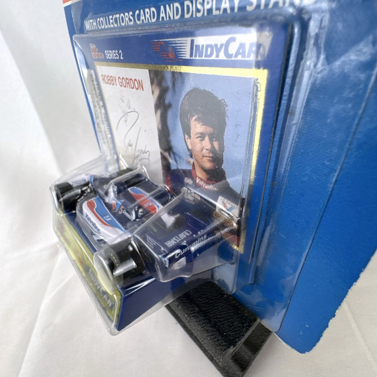Racing Champions 1:64 diecast Robby Gordon #5 Valvoline IndyCar in factory-sealed blister pack with display stand