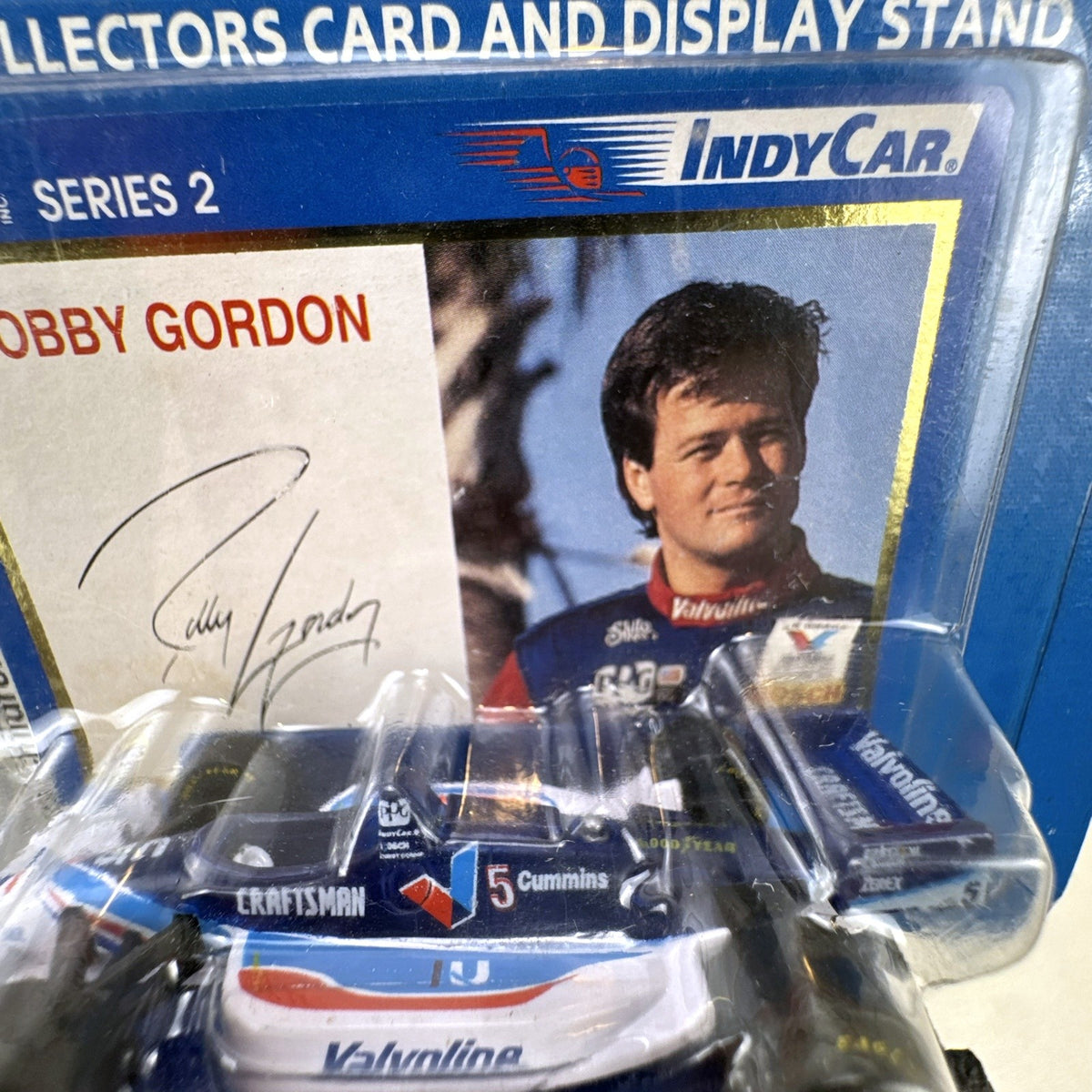 Racing Champions 1:64 diecast Robby Gordon #5 Valvoline IndyCar in factory-sealed blister pack with display stand