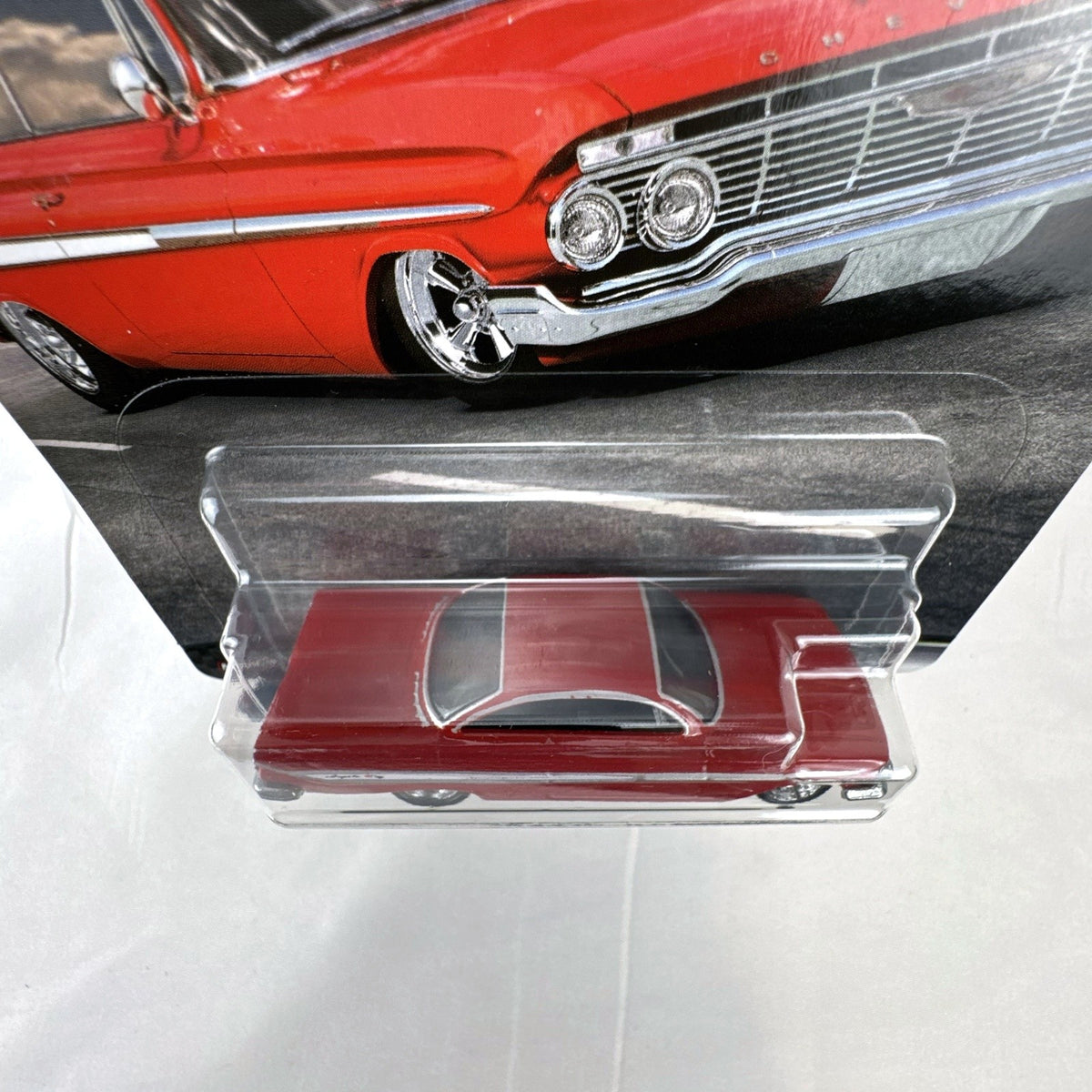 Hot Wheels Fast & Furious 1961 Chevrolet Impala 1:64 diecast car in gloss red with Real Riders tires in packaging.