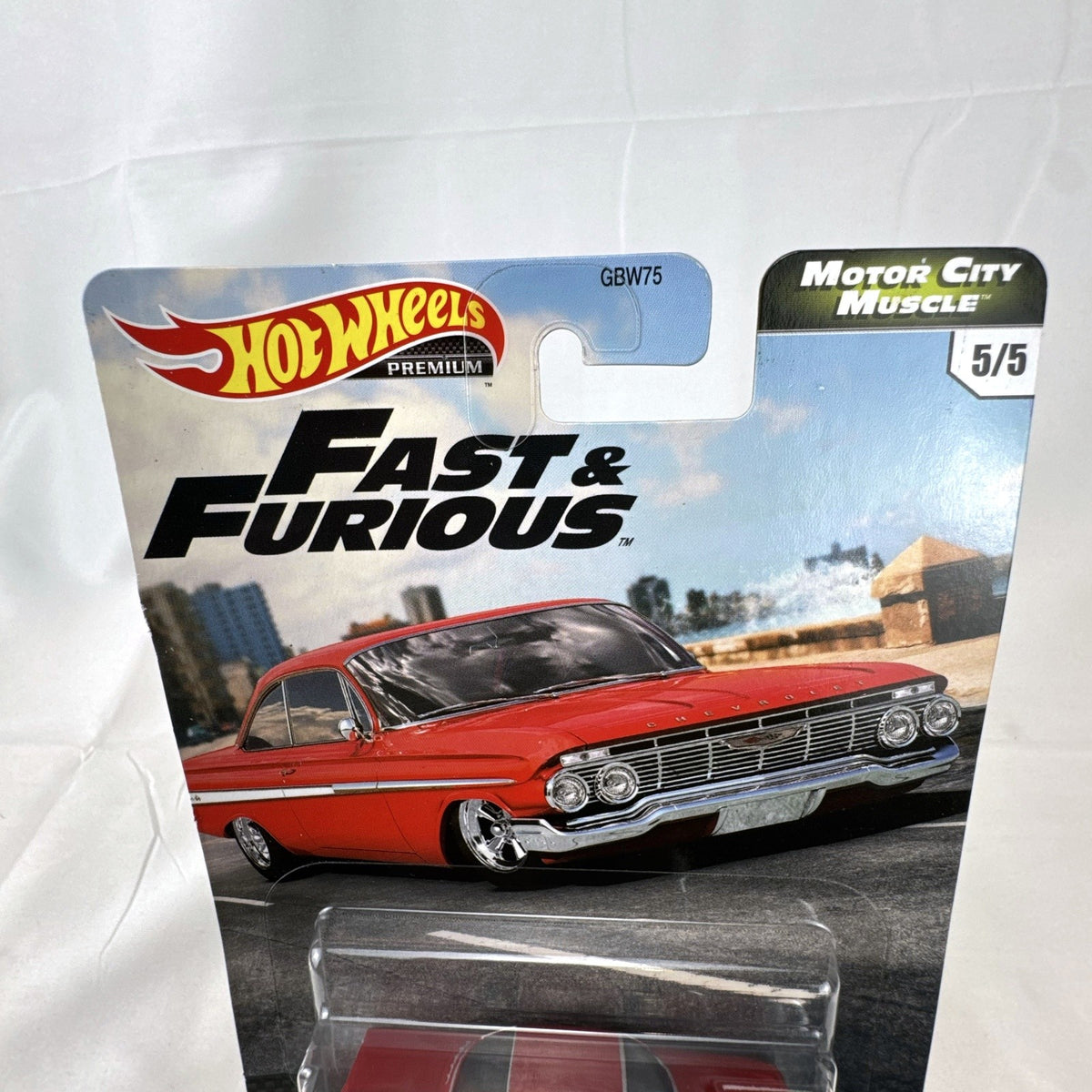 Hot Wheels Fast & Furious 1961 Chevrolet Impala 1:64 diecast car in gloss red with Real Riders tires in packaging.