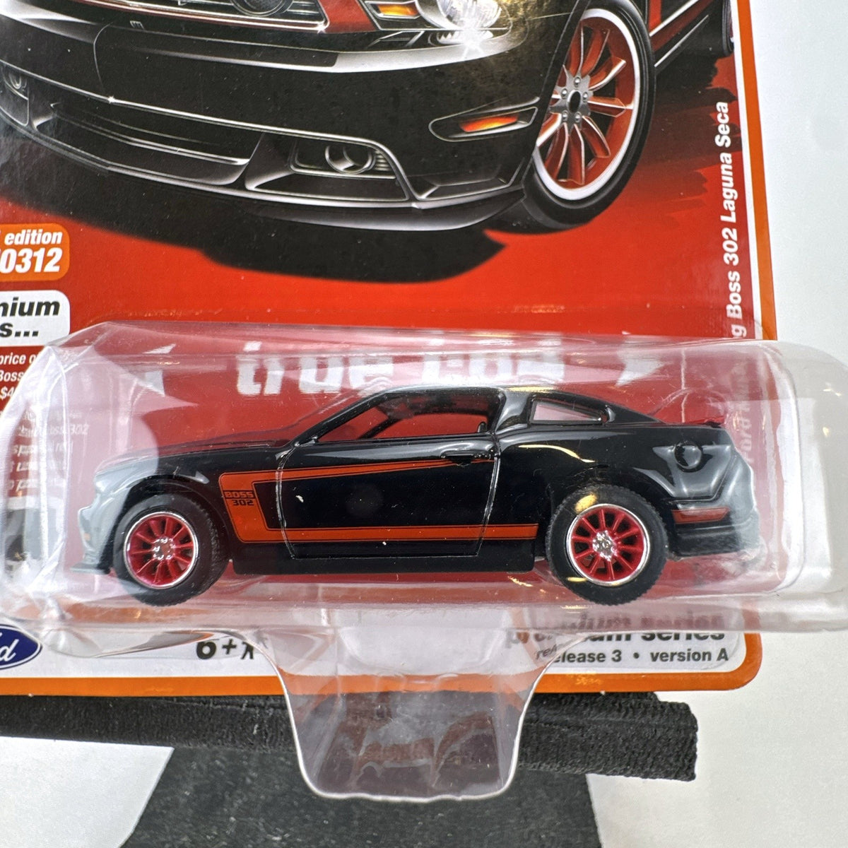 Auto World 1:64 scale 2012 Ford Mustang Boss 302 Laguna Seca diecast car in black with red accents in original packaging