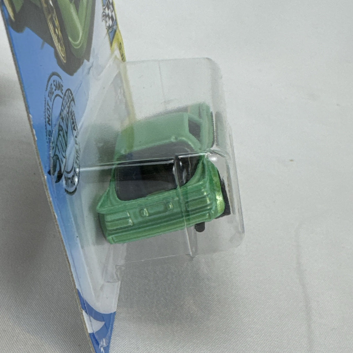 Hot Wheels 1:64 scale metallic green Mazda RX-7 diecast car in original packaging with Koni racing graphics.