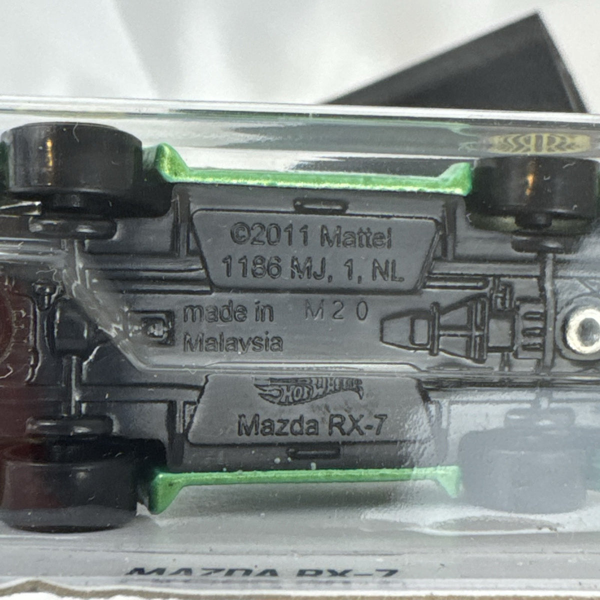 Hot Wheels 1:64 scale metallic green Mazda RX-7 diecast car in original packaging with Koni racing graphics.