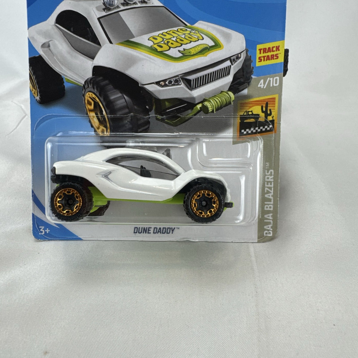 Sealed Hot Wheels 1:64 scale Dune Daddy diecast dune buggy in white with Baja Blazers graphics and gold-chrome rims.