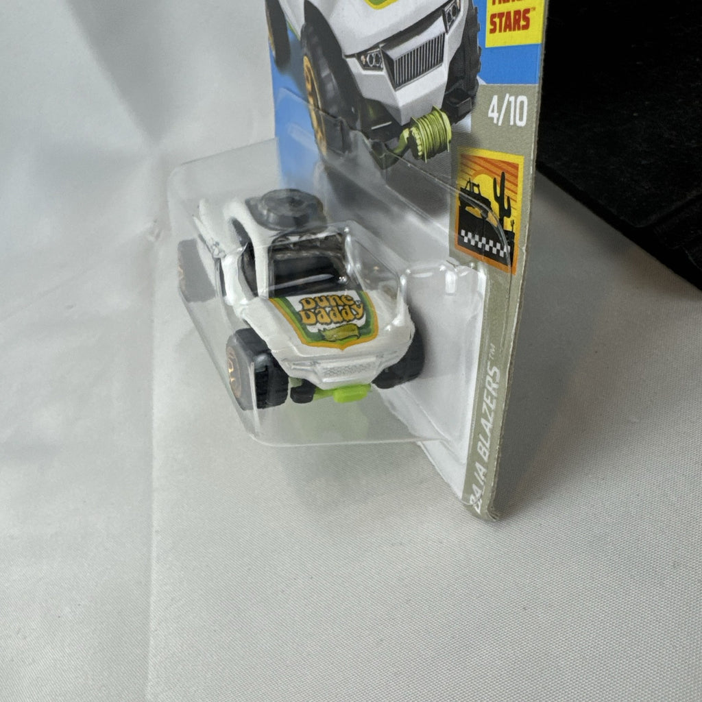 Sealed Hot Wheels 1:64 scale Dune Daddy diecast dune buggy in white with Baja Blazers graphics and gold-chrome rims.