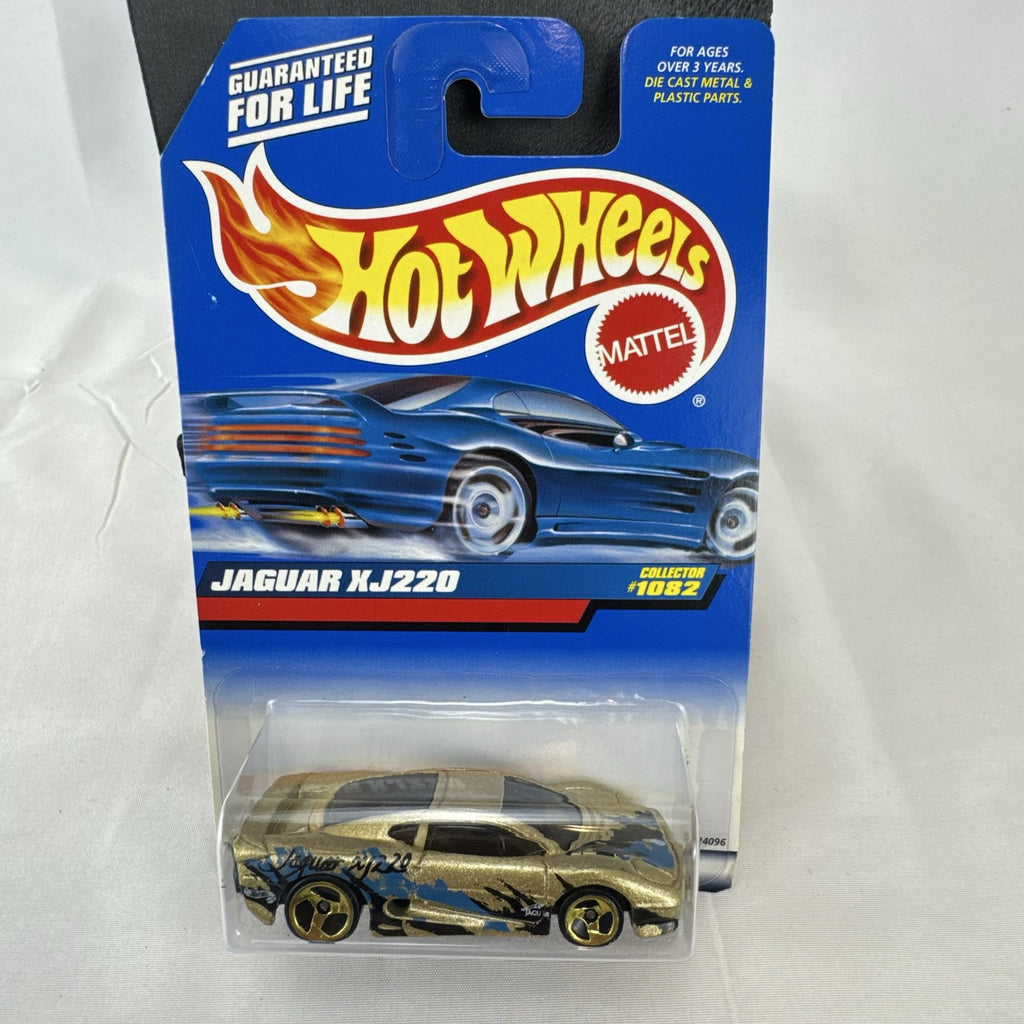 Hot Wheels 1:64 scale Jaguar XJ220 diecast car in metallic gold with 3-spoke wheels on unopened original card.