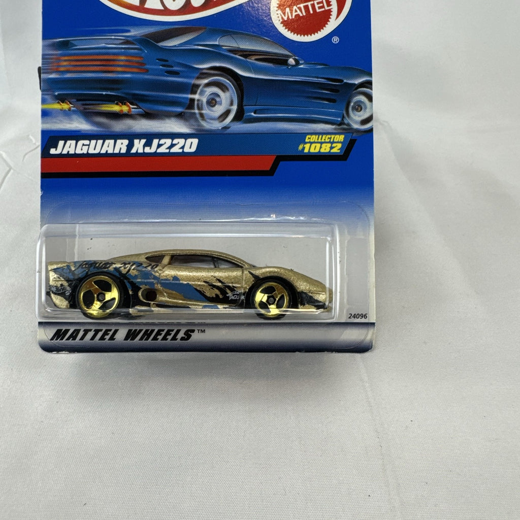 Hot Wheels 1:64 scale Jaguar XJ220 diecast car in metallic gold with 3-spoke wheels on unopened original card.