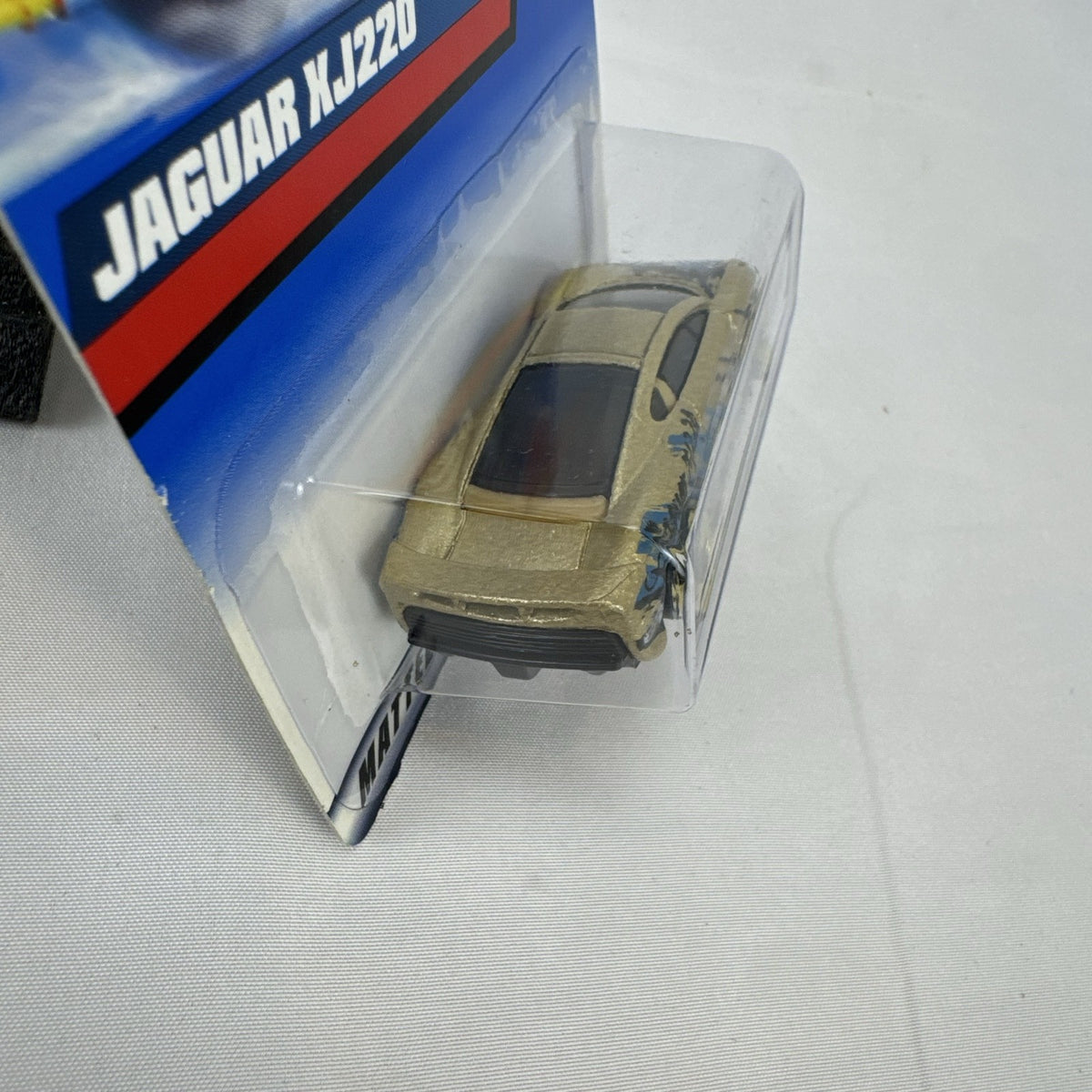 Hot Wheels 1:64 scale Jaguar XJ220 diecast car in metallic gold with 3-spoke wheels on unopened original card.