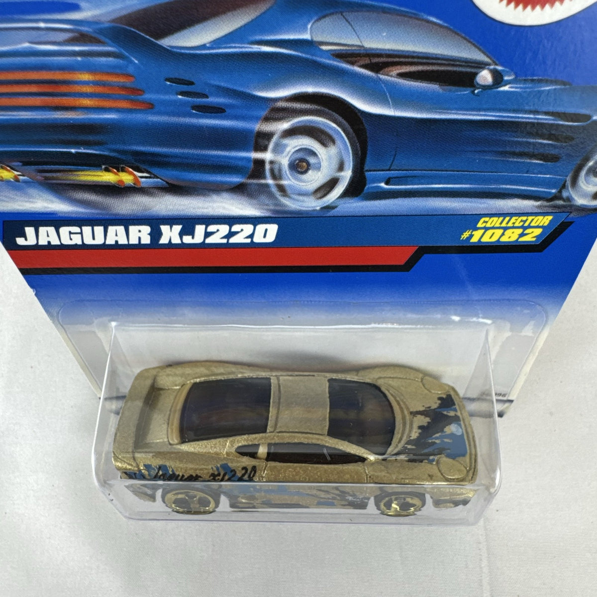 Hot Wheels 1:64 scale Jaguar XJ220 diecast car in metallic gold with 3-spoke wheels on unopened original card.