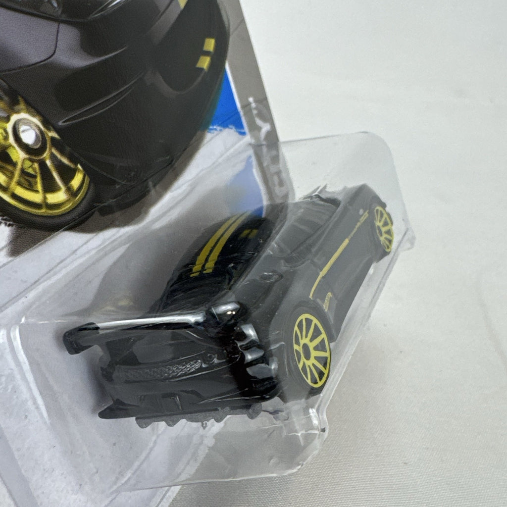 Hot Wheels 1:64 scale Lotus Evora GT4 diecast car in black with yellow stripes, factory sealed on original card