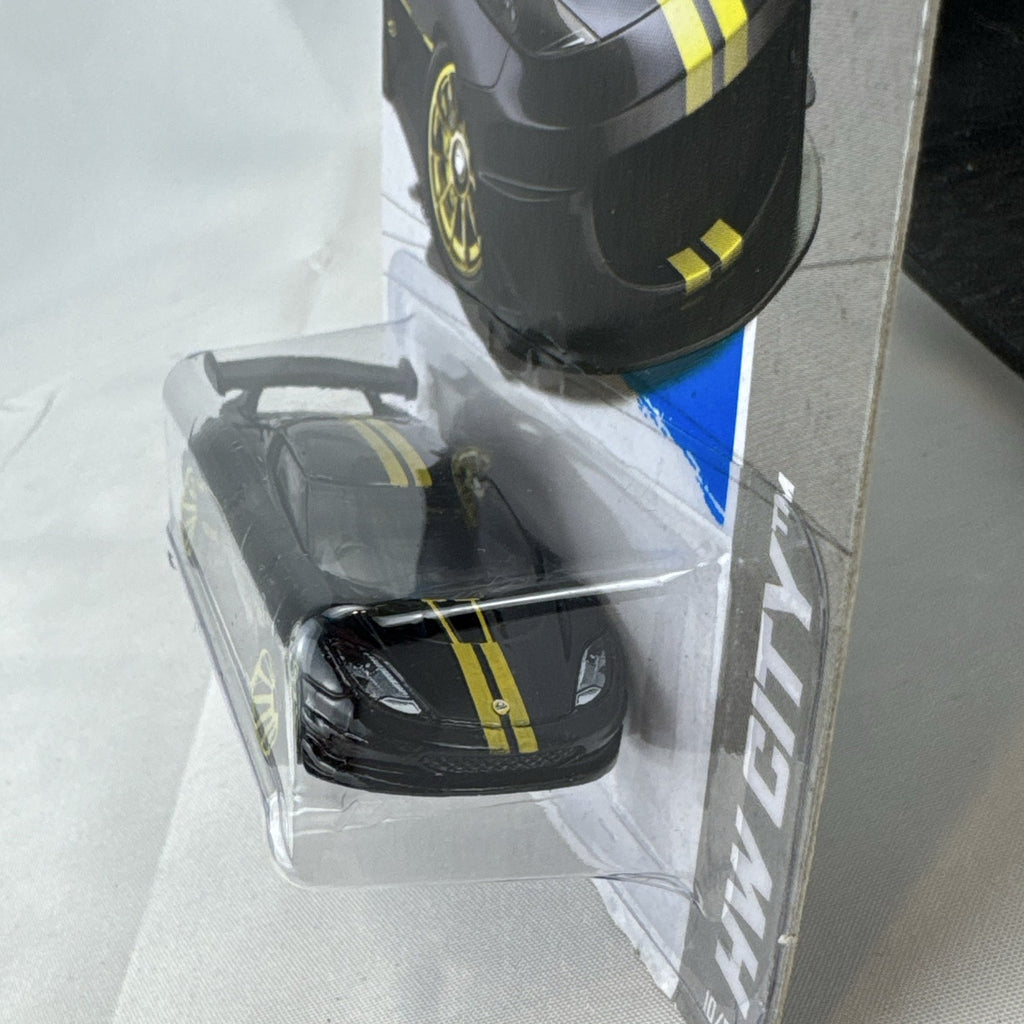 Hot Wheels 1:64 scale Lotus Evora GT4 diecast car in black with yellow stripes, factory sealed on original card