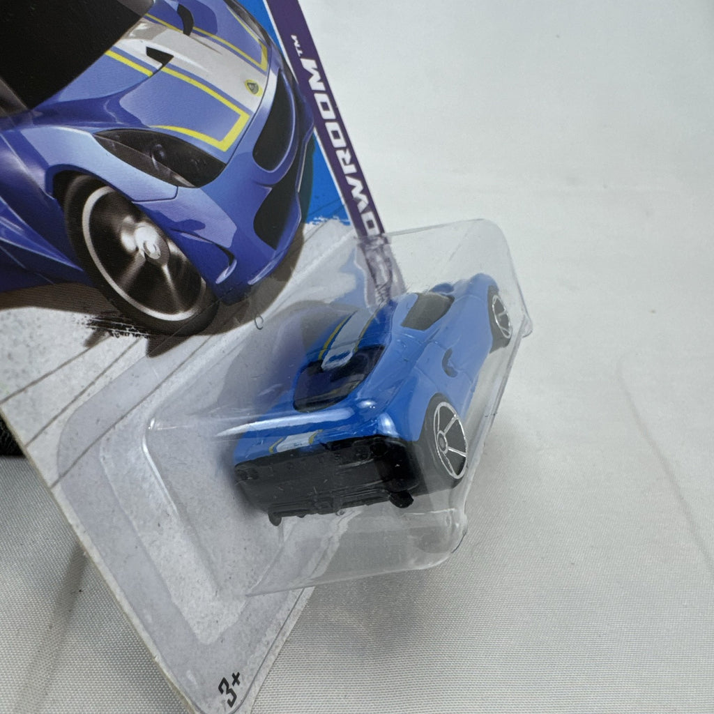 Blue Hot Wheels 1:64 scale Lotus M250 diecast car with white and yellow racing stripes sealed in original 2013 packaging.