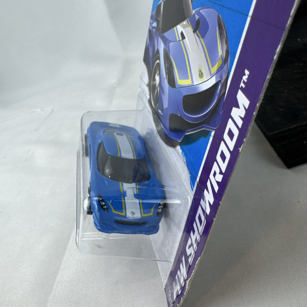 Blue Hot Wheels 1:64 scale Lotus M250 diecast car with white and yellow racing stripes sealed in original 2013 packaging.