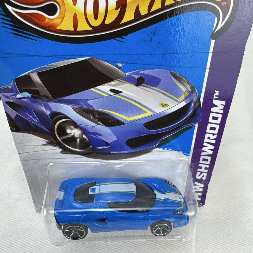 Blue Hot Wheels 1:64 scale Lotus M250 diecast car with white and yellow racing stripes sealed in original 2013 packaging.