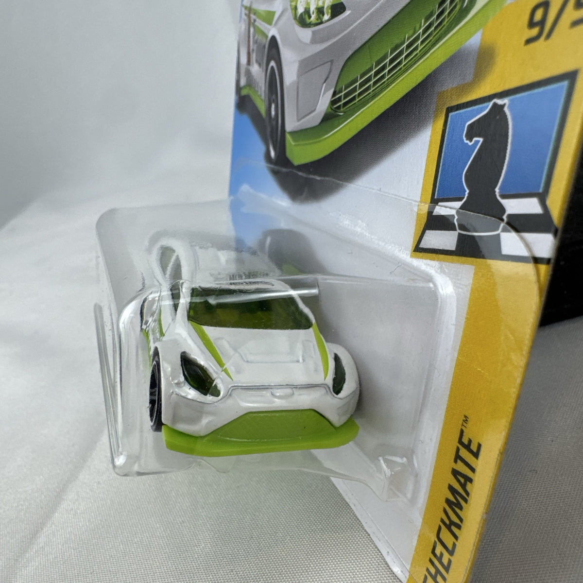 Hot Wheels 1:64 scale 2012 Ford Fiesta diecast car in white with green Pawn Checkmate graphics, sealed on card.