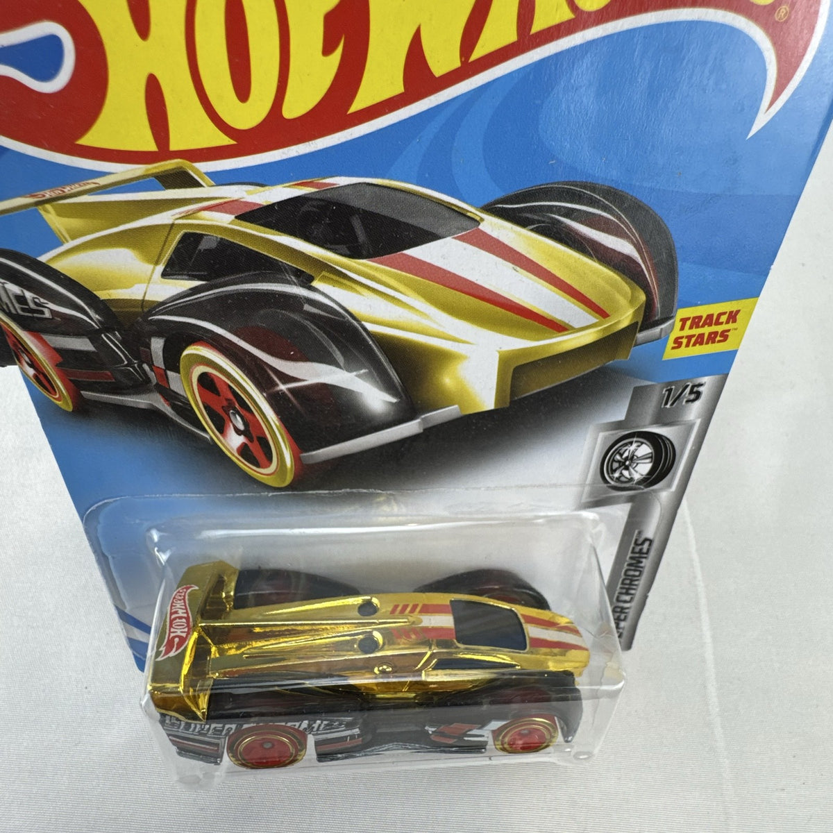 Factory sealed Hot Wheels ElecTrack 1:64 diecast car in gold chrome with red and white racing stripes on original card.