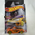 Hot Wheels 1:64 scale Scorcher diecast car in orange with Halloween graphics and yellow skull rims in sealed packaging.