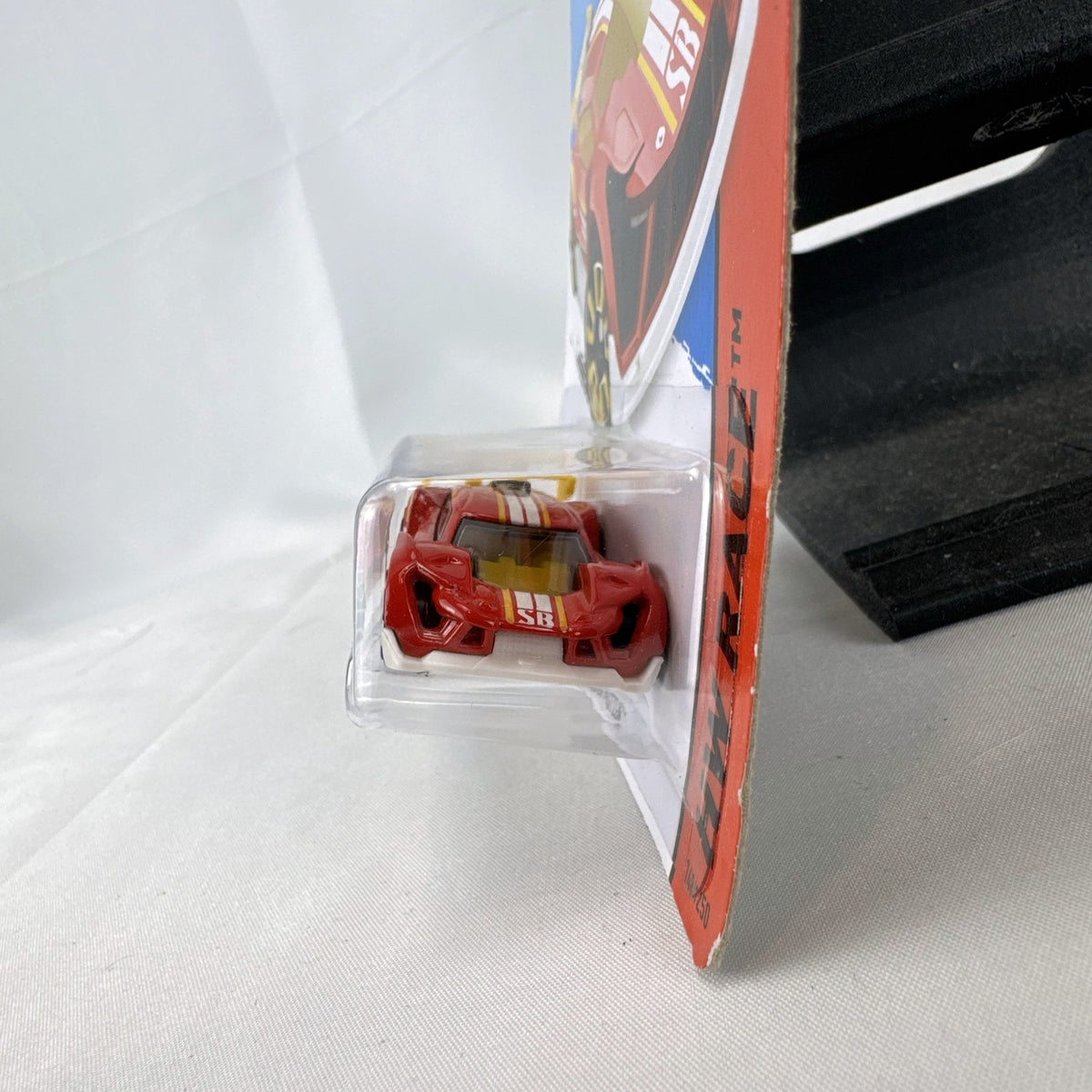 Hot Wheels Super Blitzen diecast car in red with yellow racing stripes and yellow spoiler in original blister package.