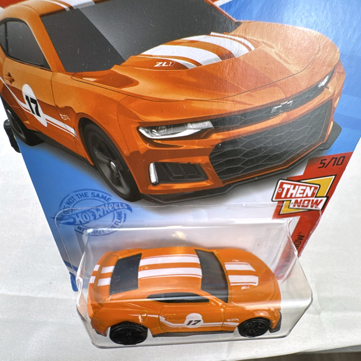 Carded Hot Wheels 1:64 scale 2017 Chevrolet Camaro ZL1 diecast car in orange with white racing stripes