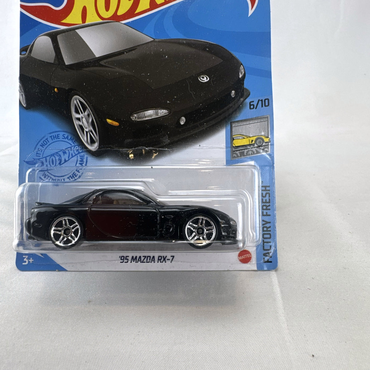 Hot Wheels 1995 Mazda RX-7 diecast 1:64 scale model car in black, sealed in original blister packaging.