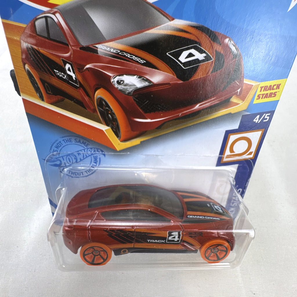 Hot Wheels Track Stars Grand Cross diecast racer in metallic red with orange wheels, sealed on card.
