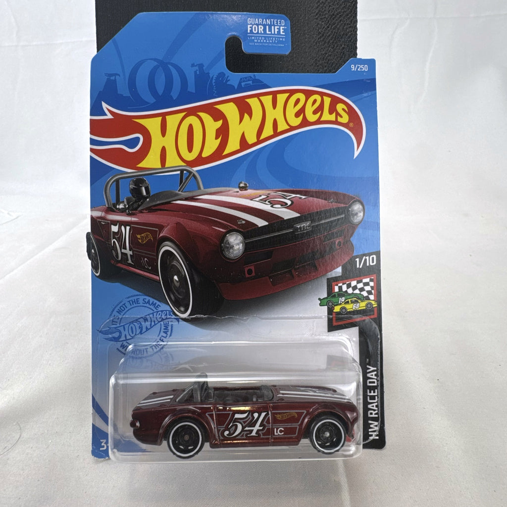 Hot Wheels Triumph TR6 HW Race Day diecast car in deep maroon red with racing stripes in original blister card packaging