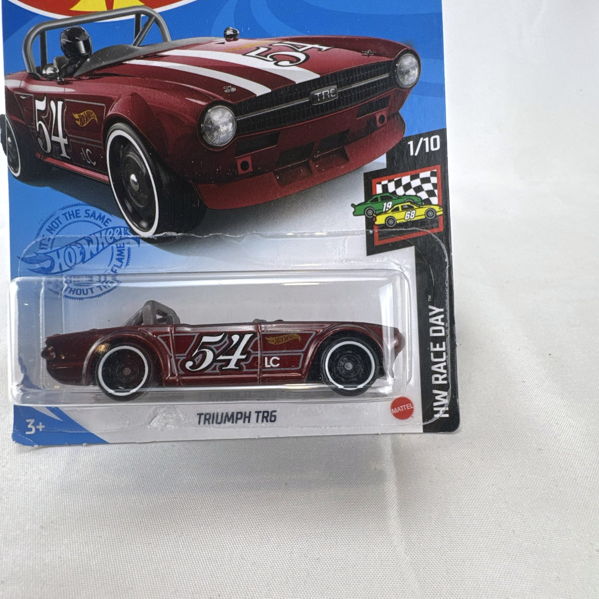 Hot Wheels Triumph TR6 HW Race Day diecast car in deep maroon red with racing stripes in original blister card packaging