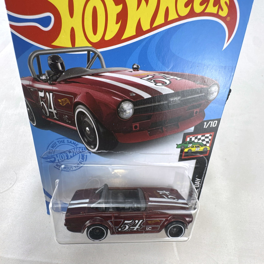 Hot Wheels Triumph TR6 HW Race Day diecast car in deep maroon red with racing stripes in original blister card packaging