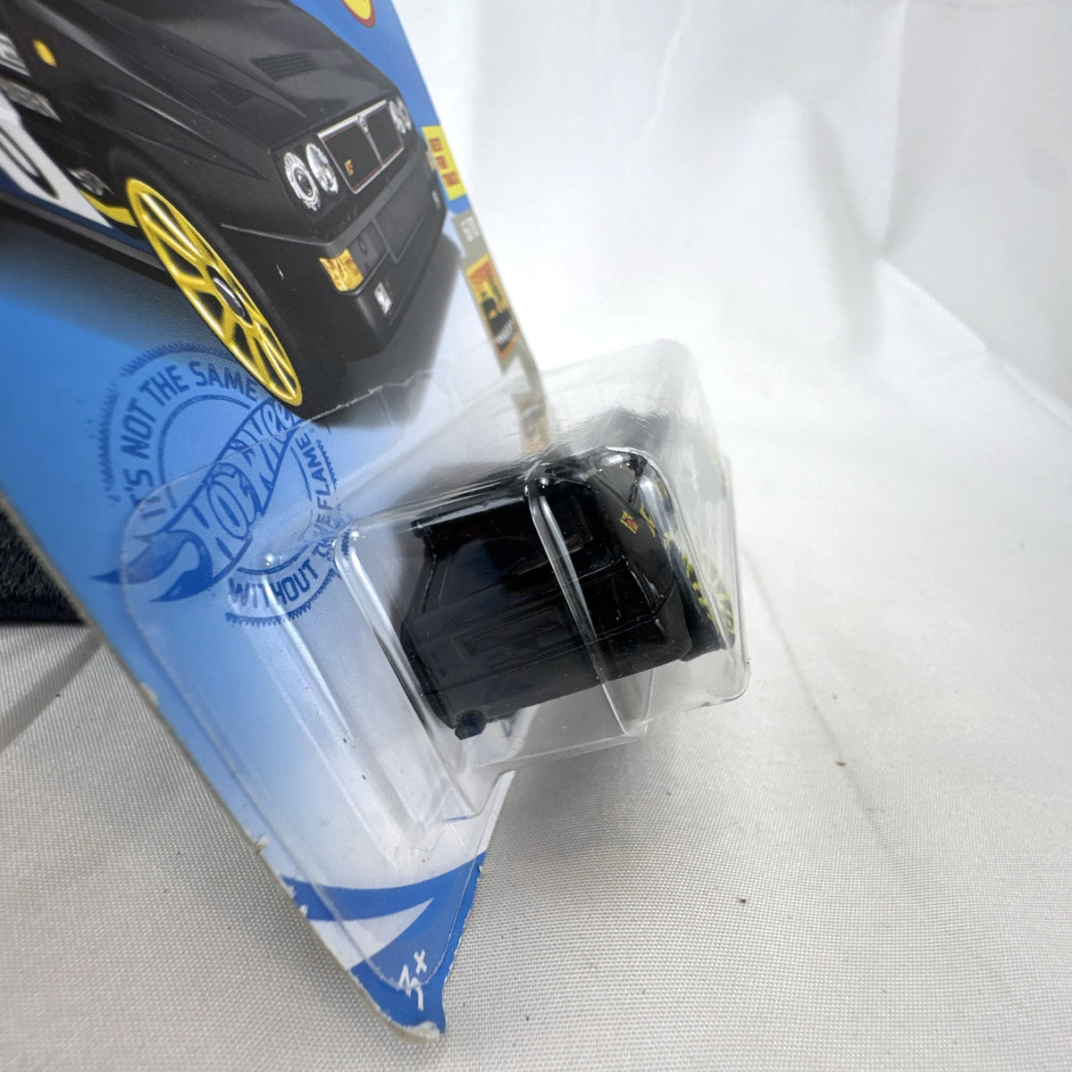Hot Wheels 1:64 scale 1994 Lancia Delta Integrale diecast rally car in black with yellow wheels, sealed in package