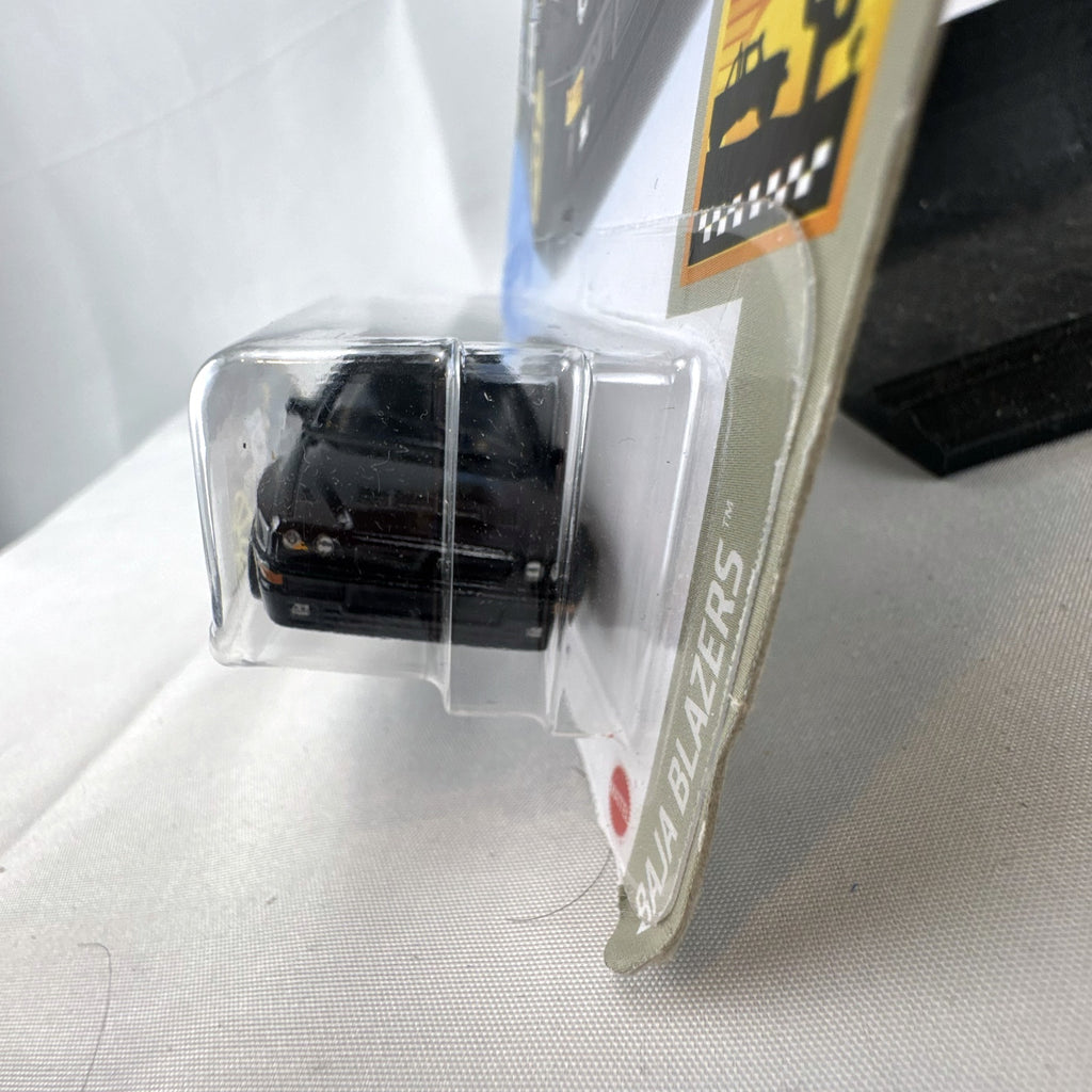 Hot Wheels 1:64 scale 1994 Lancia Delta Integrale diecast rally car in black with yellow wheels, sealed in package
