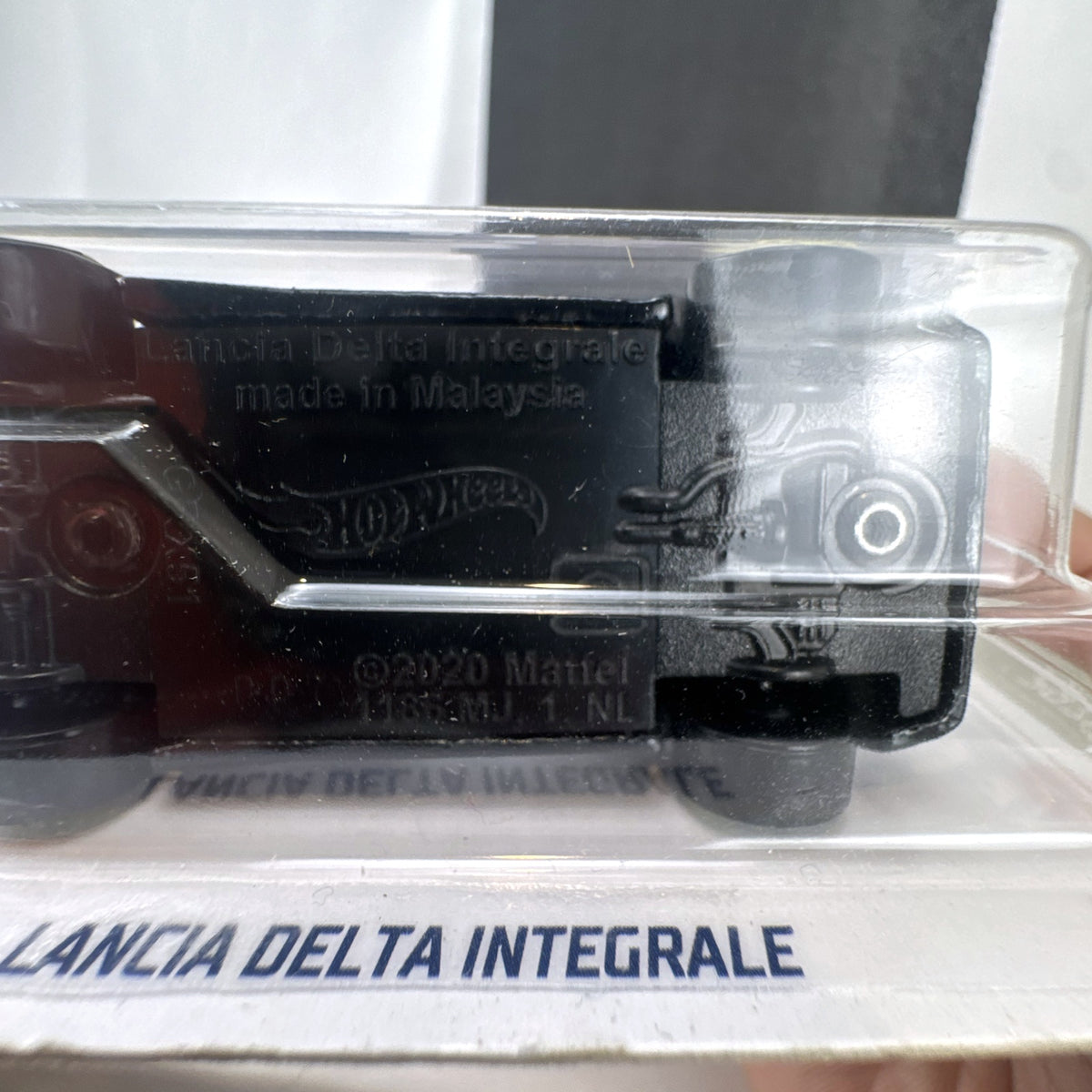 Hot Wheels 1:64 scale 1994 Lancia Delta Integrale diecast rally car in black with yellow wheels, sealed in package