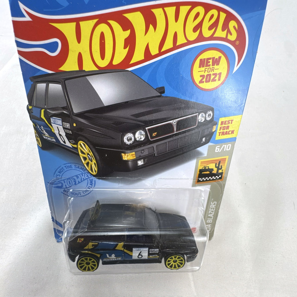 Hot Wheels 1:64 scale 1994 Lancia Delta Integrale diecast rally car in black with yellow wheels, sealed in package