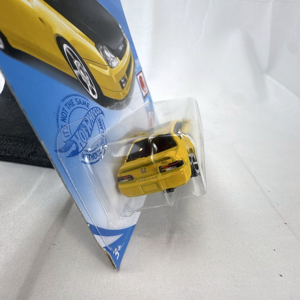 Hot Wheels 1:64 scale 1998 Honda Prelude diecast car in bright yellow with black hood on packaging
