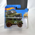 Hot Wheels 1:64 scale Land Rover Defender 90 diecast SUV in olive green with mud splatter on card