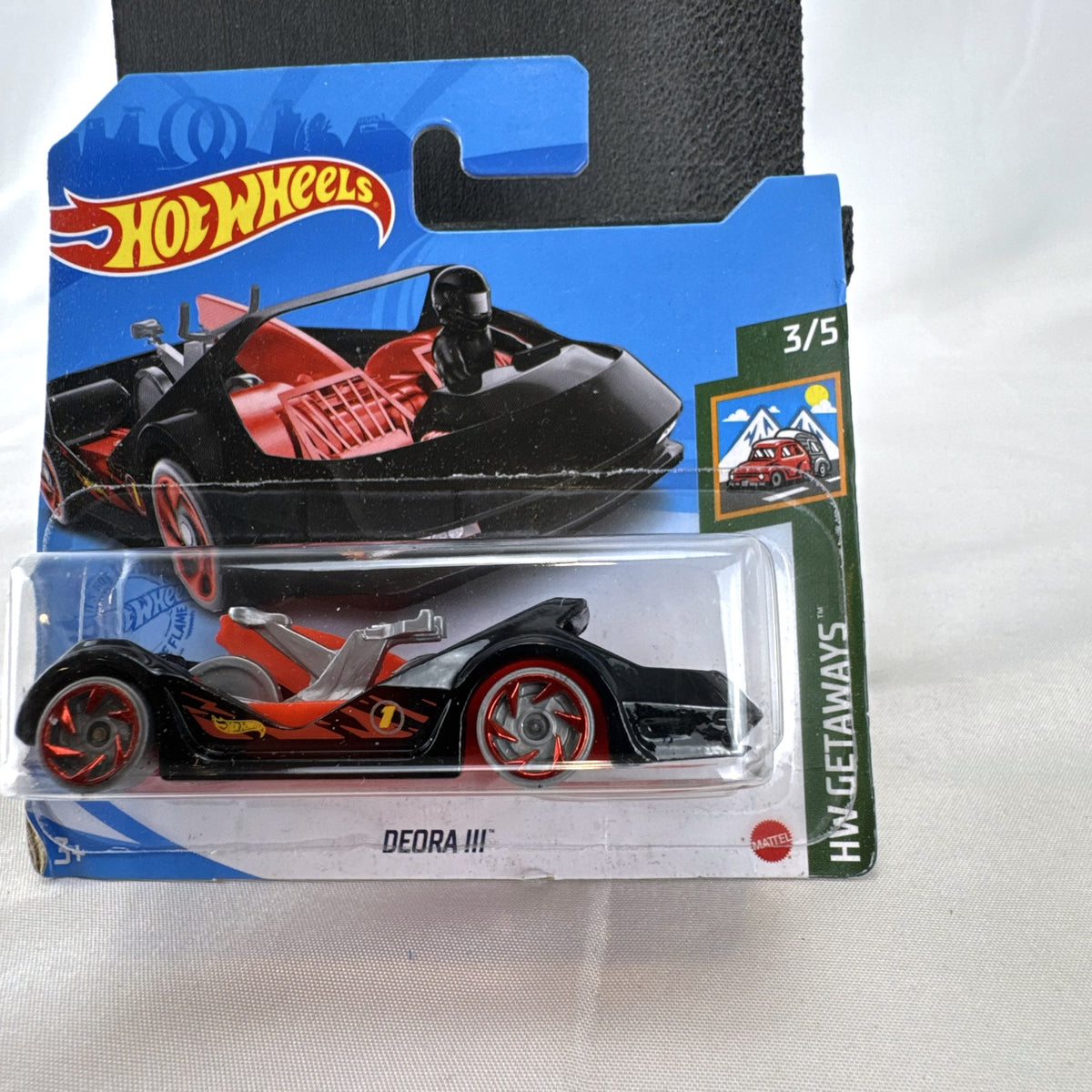 Hot Wheels Deora III 1:64 scale diecast car in black on factory-sealed international short card packaging