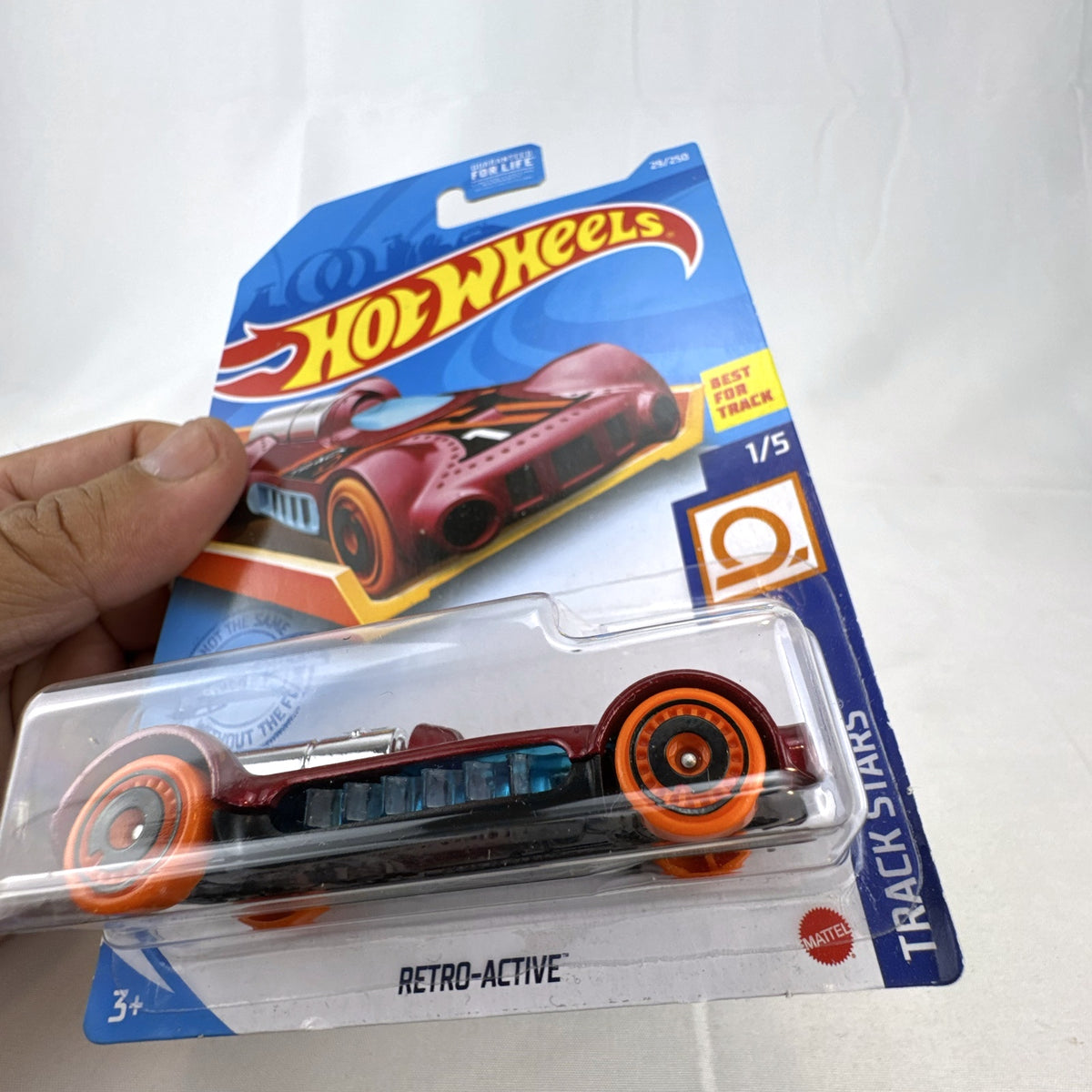 Hot Wheels Retro-Active diecast car in metallic maroon on original Track Stars blister card packaging.