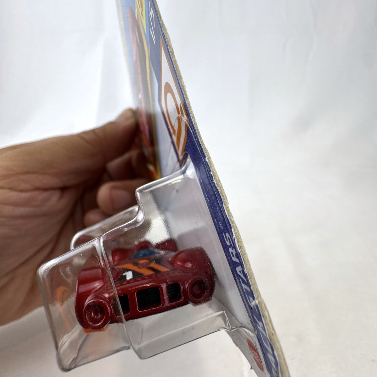 Hot Wheels Retro-Active diecast car in metallic maroon on original Track Stars blister card packaging.