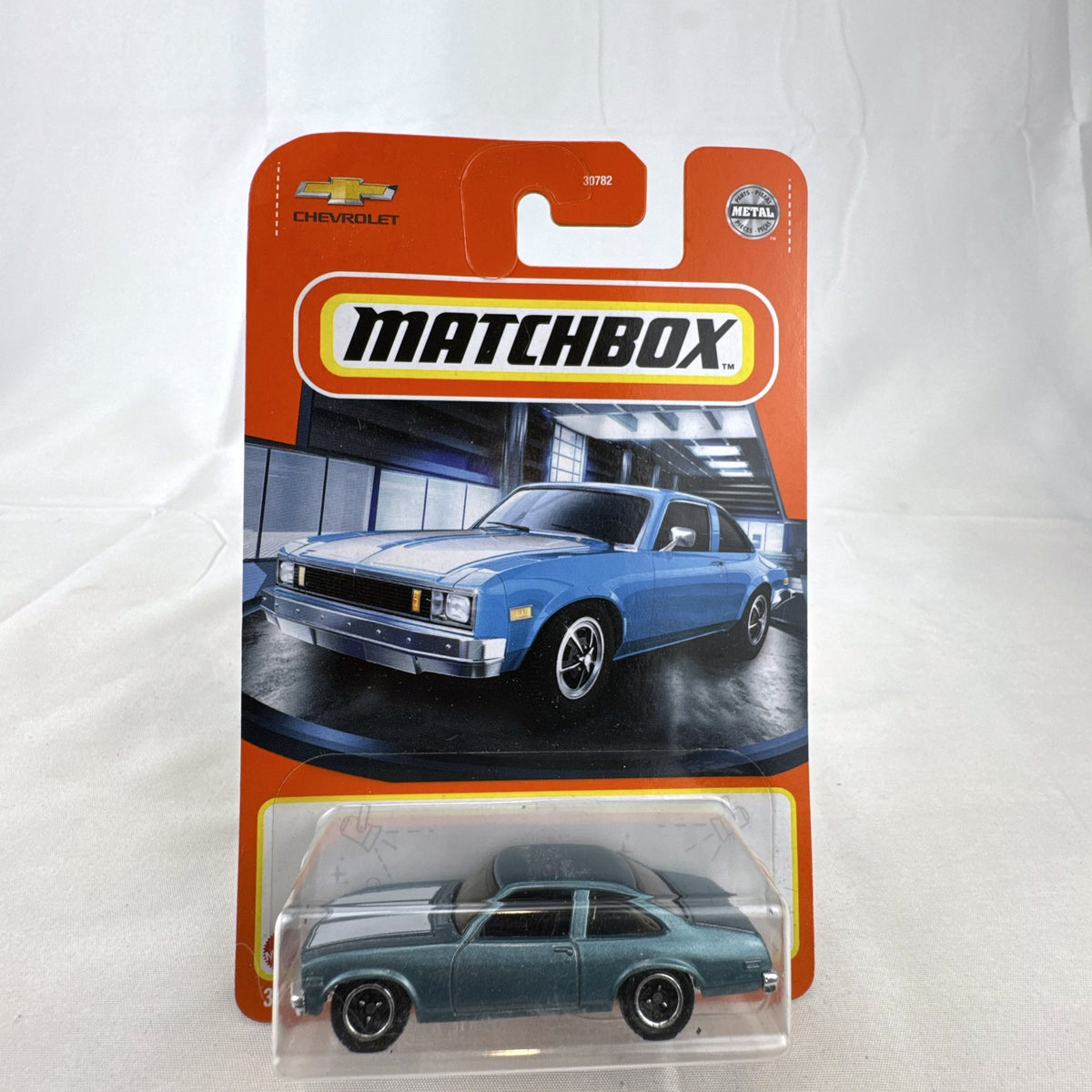 Matchbox 1979 Chevrolet Nova 1:64 scale diecast car in metallic blue with white hood stripes