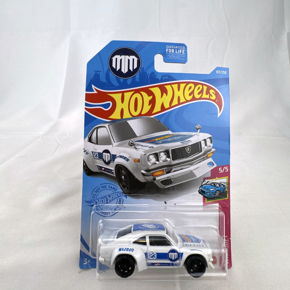 White Hot Wheels 1:64 scale Mazda RX-3 diecast car in Mad Mike HW Drift livery sealed on card.