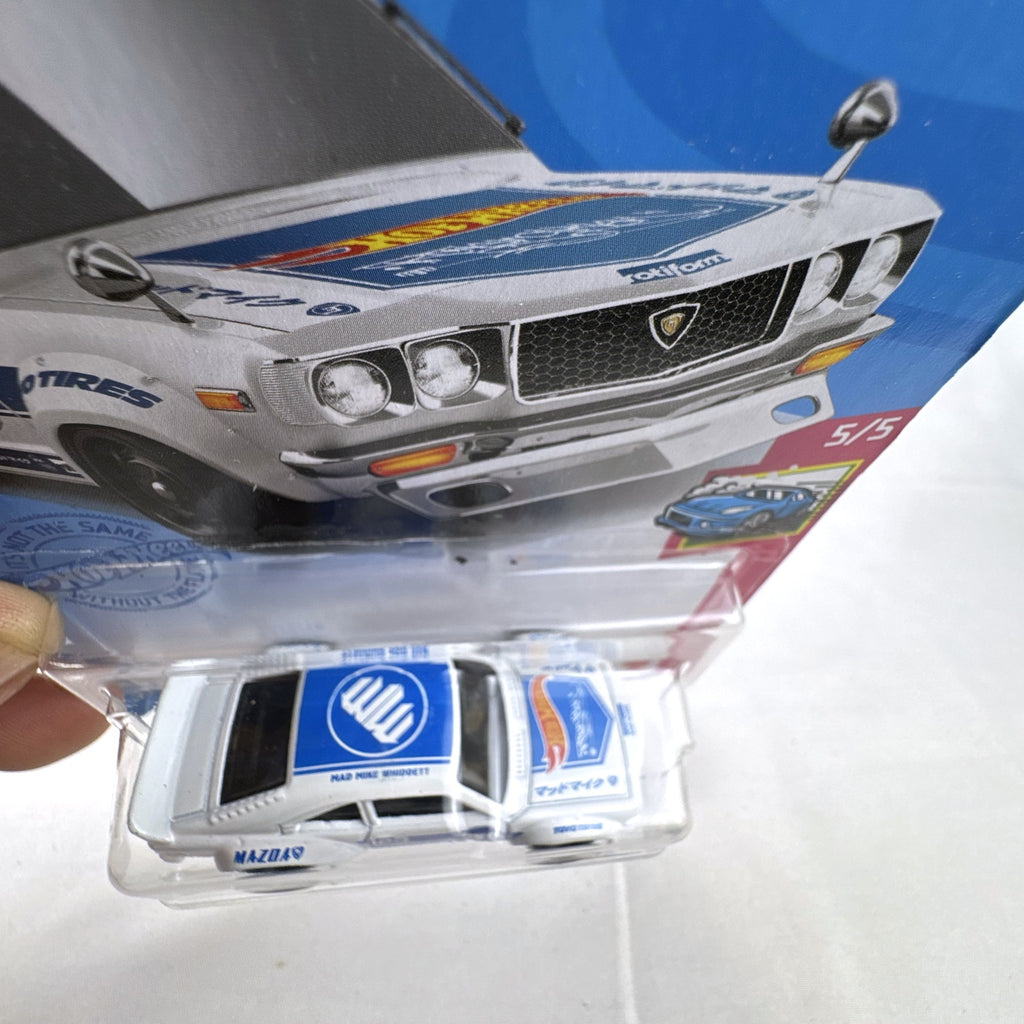 White Hot Wheels 1:64 scale Mazda RX-3 diecast car in Mad Mike HW Drift livery sealed on card.