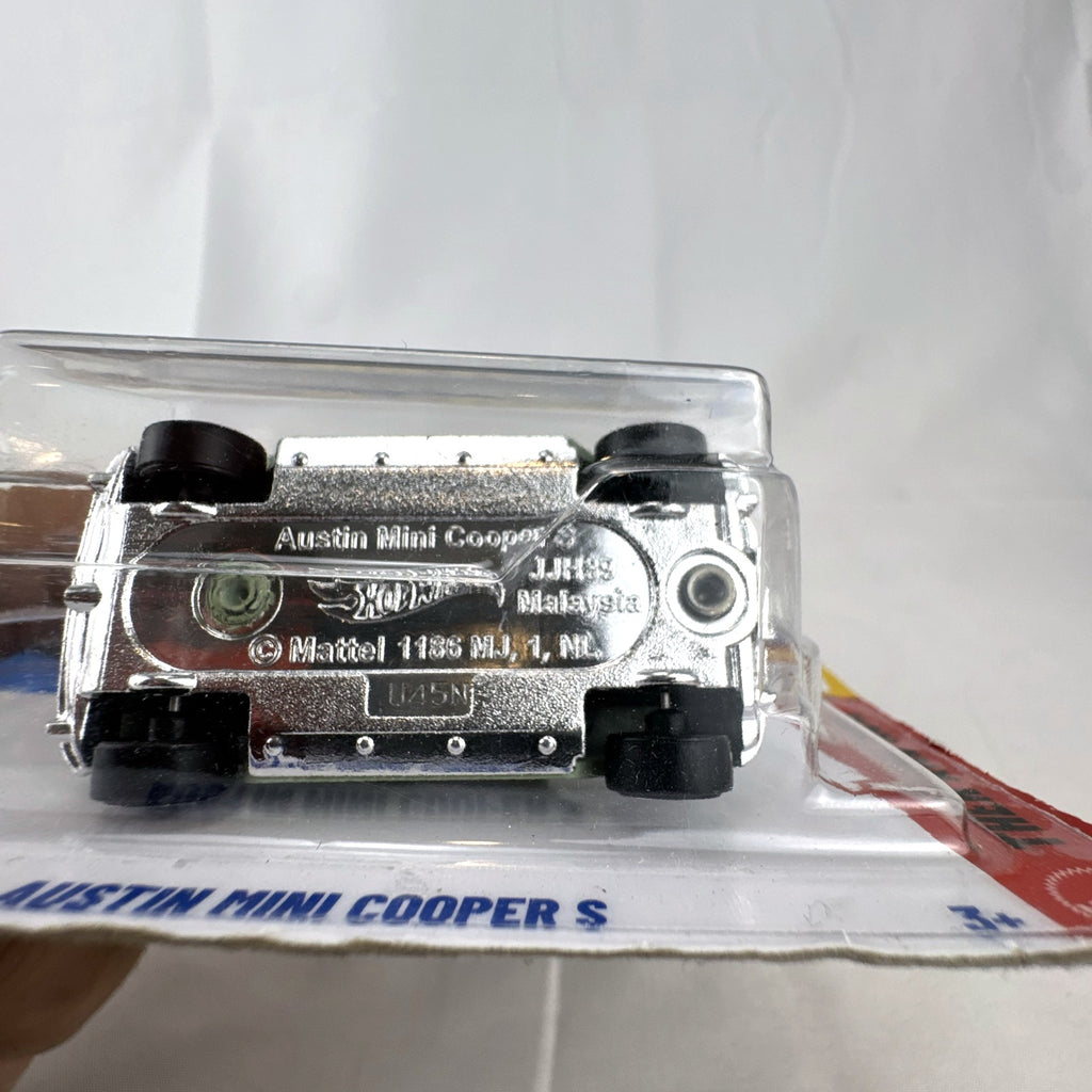 Hot Wheels 1965 Austin Mini Cooper S diecast car in sage green with white stripes, factory sealed in original packaging
