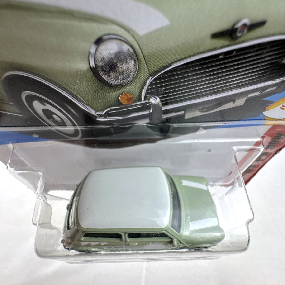 Hot Wheels 1965 Austin Mini Cooper S diecast car in sage green with white stripes, factory sealed in original packaging