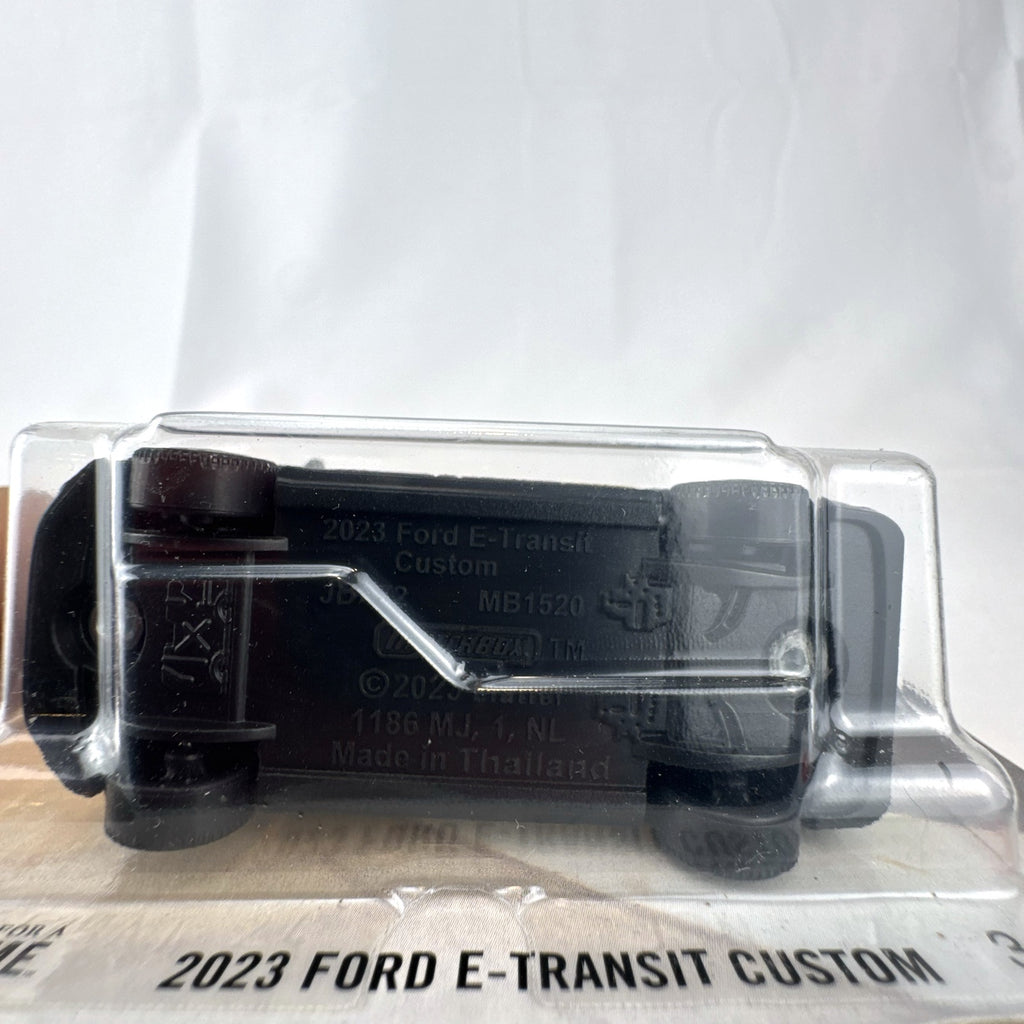 Matchbox 2023 Ford E-Transit Custom diecast van in gray with MBX Edition livery, sealed on card.
