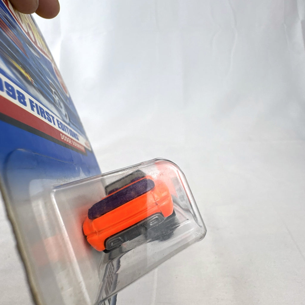 Factory sealed 1998 Hot Wheels First Editions Dodge Sidewinder diecast truck in neon orange on original card.